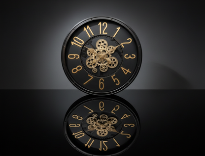Decorative clock with gold numbers and intricate design on a reflective surface.